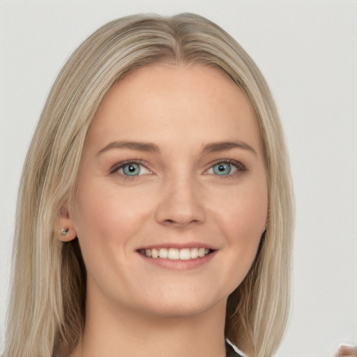 Joyful white young-adult female with long  blond hair and green eyes