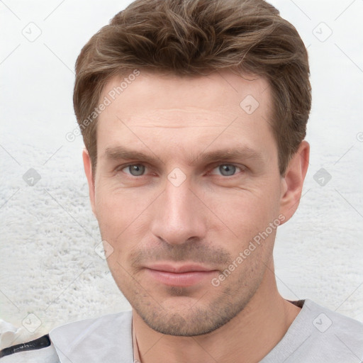 Joyful white young-adult male with short  brown hair and grey eyes