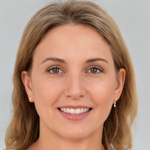 Joyful white young-adult female with medium  brown hair and green eyes