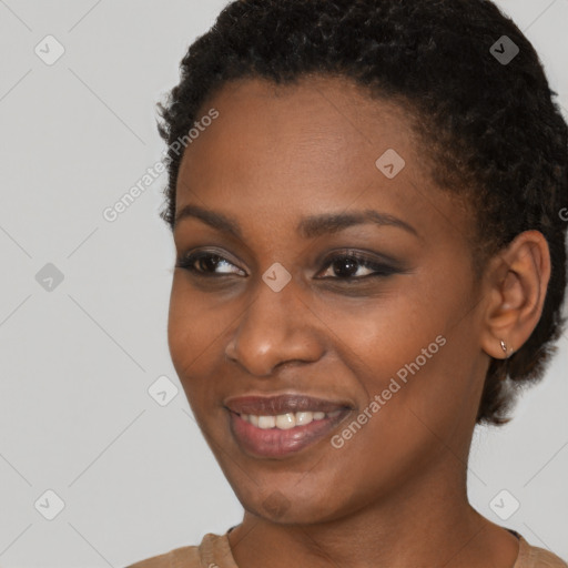 Joyful black young-adult female with short  black hair and brown eyes