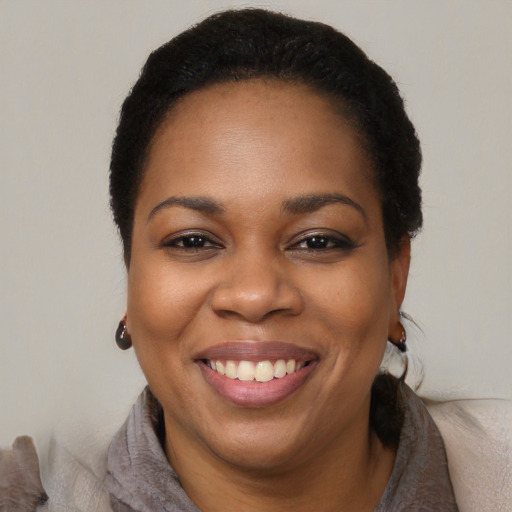 Joyful black adult female with short  black hair and brown eyes
