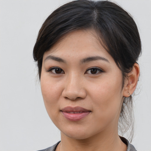Joyful asian young-adult female with medium  brown hair and brown eyes