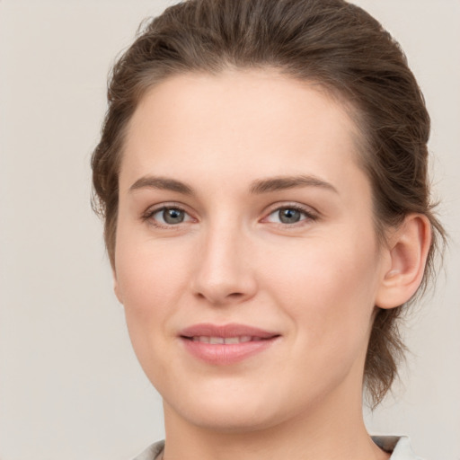 Joyful white young-adult female with short  brown hair and grey eyes