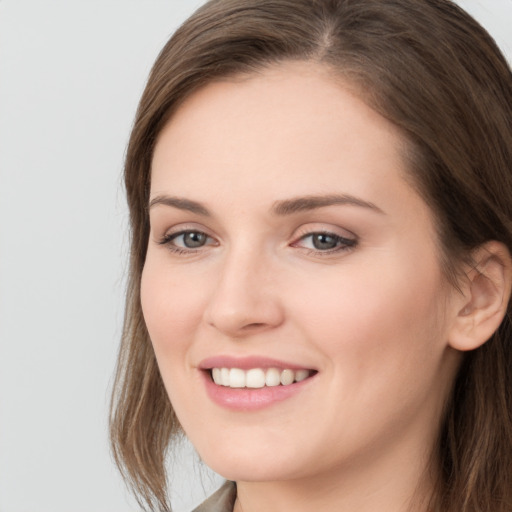 Joyful white young-adult female with long  brown hair and grey eyes