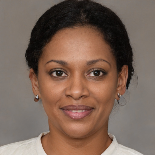 Joyful black young-adult female with short  brown hair and brown eyes