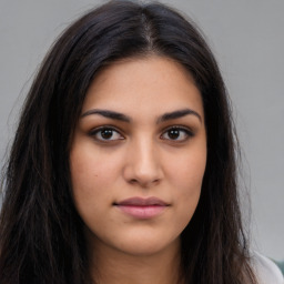 Joyful latino young-adult female with long  brown hair and brown eyes