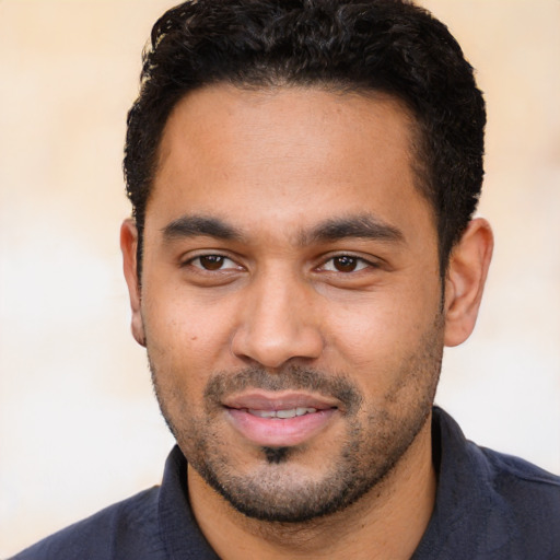 Joyful latino young-adult male with short  black hair and brown eyes
