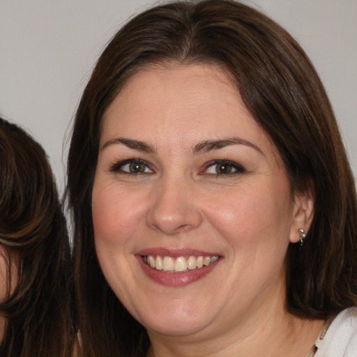 Joyful white adult female with medium  brown hair and brown eyes