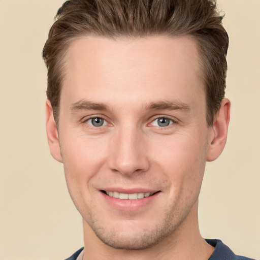 Joyful white young-adult male with short  brown hair and grey eyes