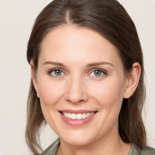 Joyful white young-adult female with medium  brown hair and grey eyes