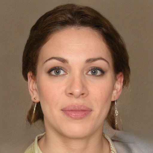 Joyful white young-adult female with medium  brown hair and green eyes