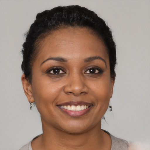 Joyful black young-adult female with short  brown hair and brown eyes
