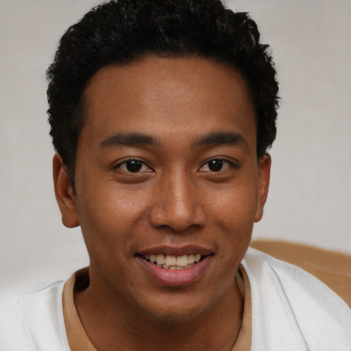 Joyful latino young-adult male with short  brown hair and brown eyes