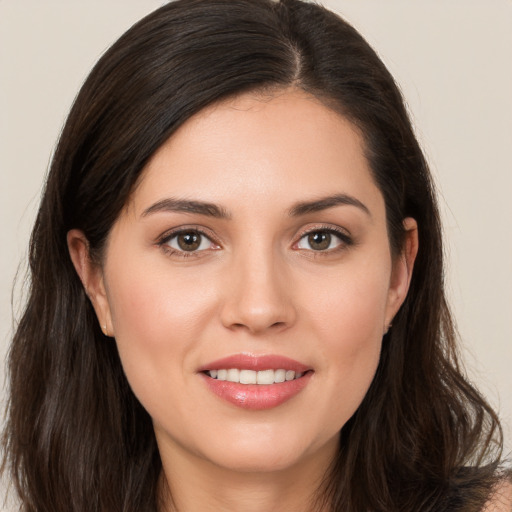 Joyful white young-adult female with long  brown hair and brown eyes