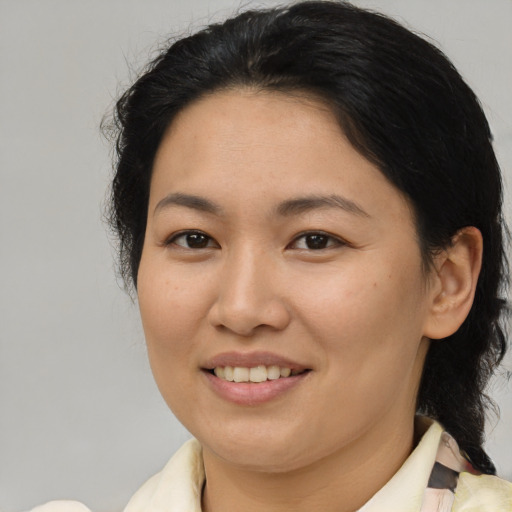 Joyful asian adult female with medium  brown hair and brown eyes