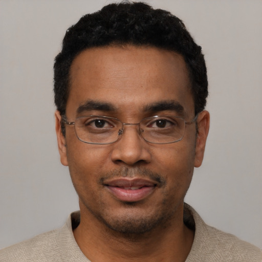 Joyful black young-adult male with short  black hair and brown eyes
