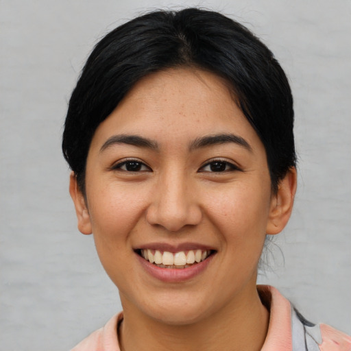 Joyful asian young-adult female with short  black hair and brown eyes