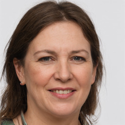 Joyful white adult female with medium  brown hair and grey eyes