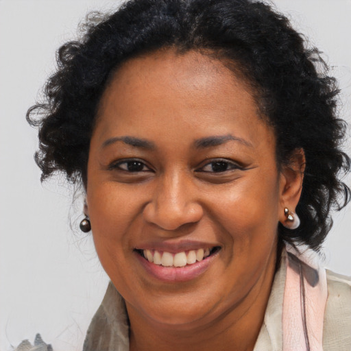 Joyful black adult female with long  brown hair and brown eyes