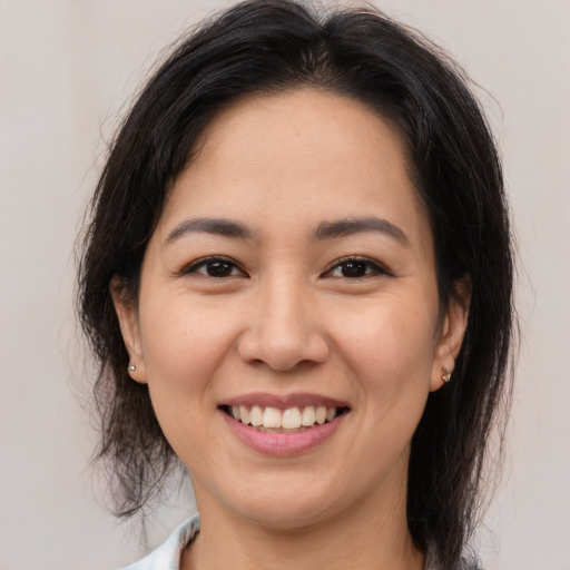 Joyful asian young-adult female with medium  brown hair and brown eyes