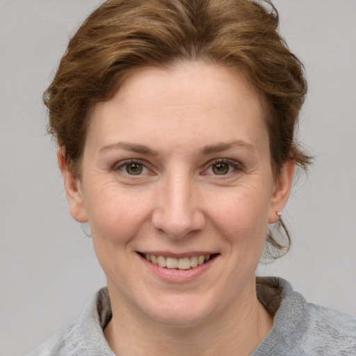 Joyful white adult female with short  brown hair and blue eyes