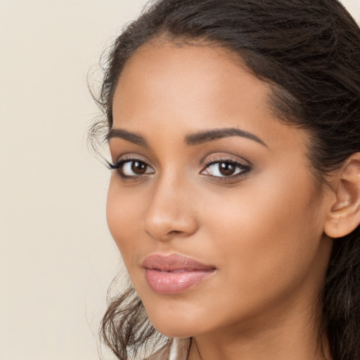 Joyful latino young-adult female with long  brown hair and brown eyes