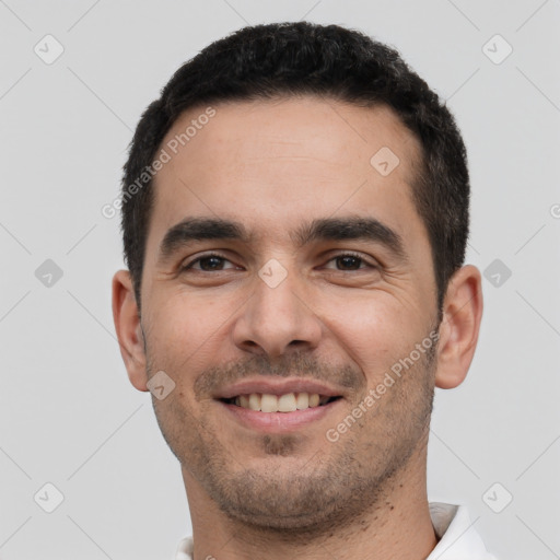 Joyful white young-adult male with short  black hair and brown eyes