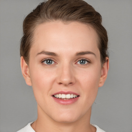 Joyful white young-adult female with short  brown hair and grey eyes