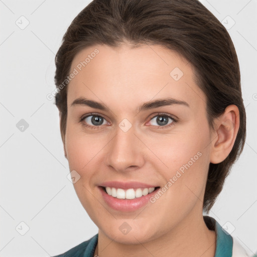 Joyful white young-adult female with medium  brown hair and grey eyes