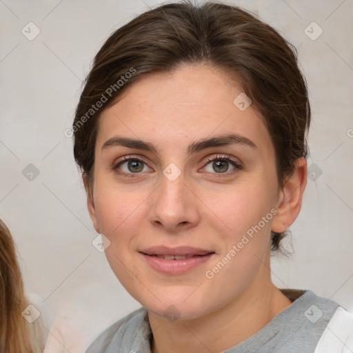 Joyful white young-adult female with medium  brown hair and grey eyes