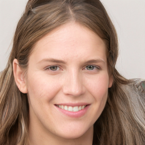 Joyful white young-adult female with long  brown hair and grey eyes