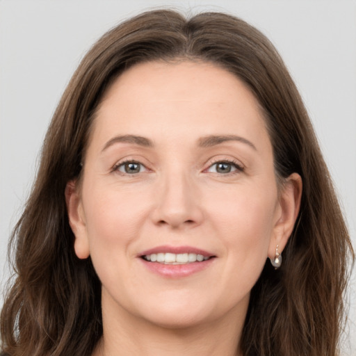 Joyful white adult female with long  brown hair and grey eyes