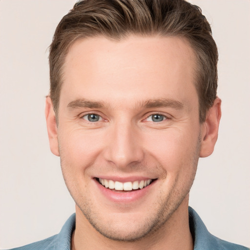 Joyful white young-adult male with short  brown hair and grey eyes