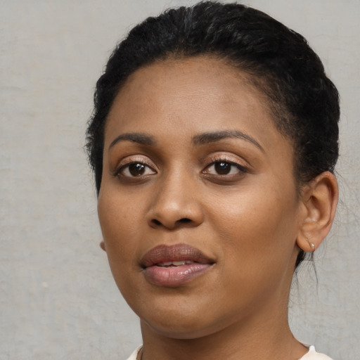 Joyful black young-adult female with short  black hair and brown eyes