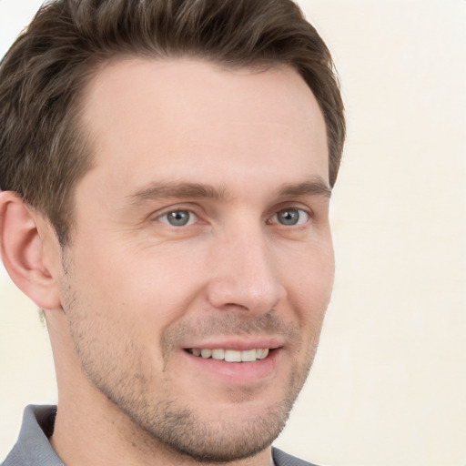 Joyful white young-adult male with short  brown hair and grey eyes