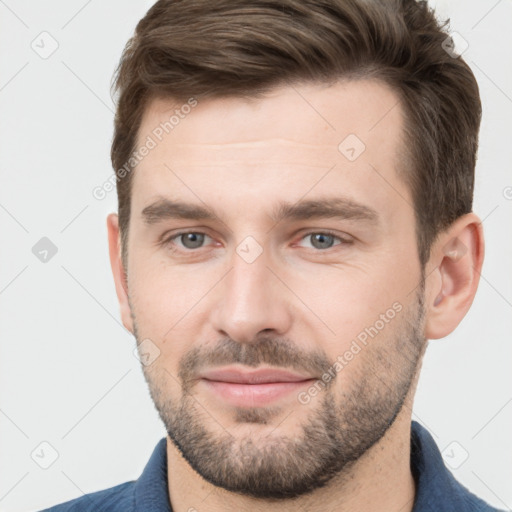 Joyful white young-adult male with short  brown hair and grey eyes