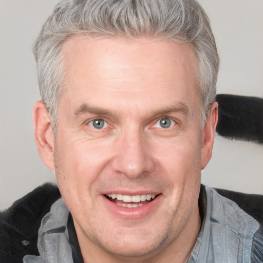 Joyful white middle-aged male with short  brown hair and blue eyes