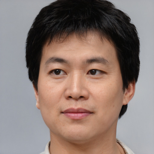 Joyful asian young-adult male with short  brown hair and brown eyes