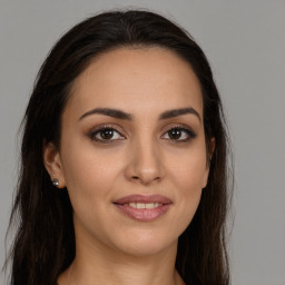 Joyful white young-adult female with long  brown hair and brown eyes