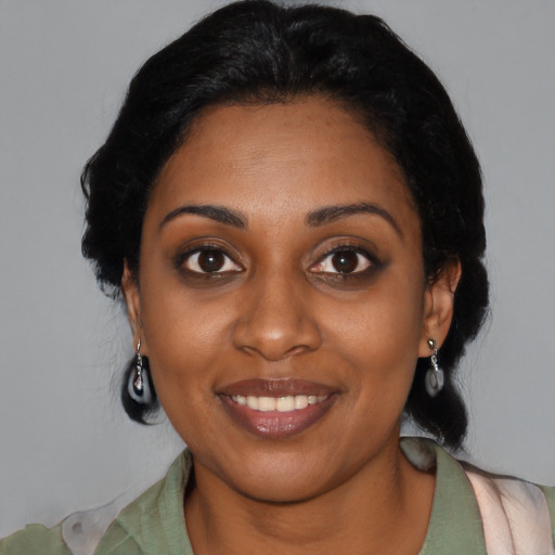 Joyful black young-adult female with long  black hair and brown eyes