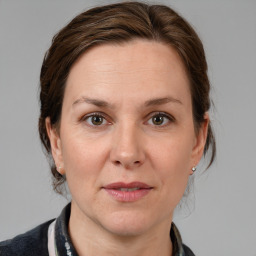 Joyful white adult female with medium  brown hair and grey eyes