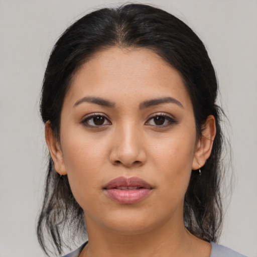 Joyful latino young-adult female with medium  brown hair and brown eyes