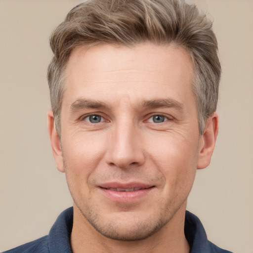 Joyful white adult male with short  brown hair and grey eyes