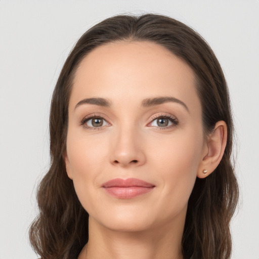 Joyful white young-adult female with long  brown hair and brown eyes