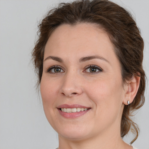 Joyful white young-adult female with medium  brown hair and green eyes