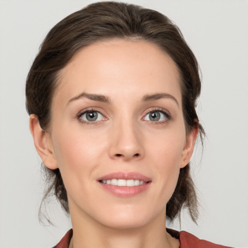 Joyful white young-adult female with medium  brown hair and grey eyes