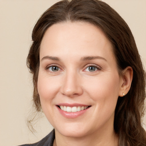 Joyful white young-adult female with long  brown hair and grey eyes