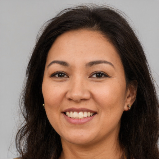 Joyful latino adult female with long  brown hair and brown eyes