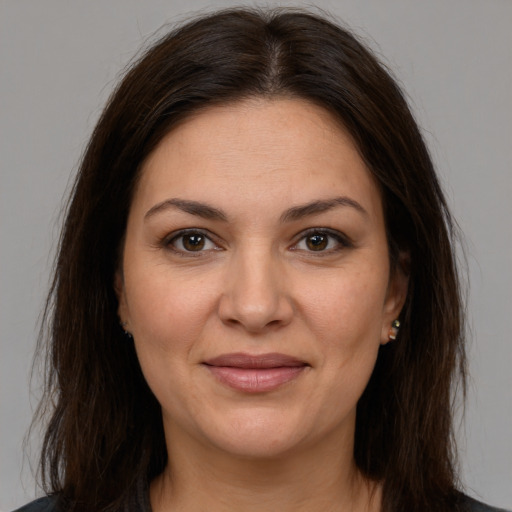 Joyful white young-adult female with long  brown hair and brown eyes