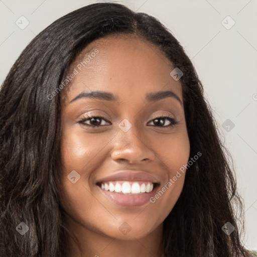 Joyful black young-adult female with long  brown hair and brown eyes